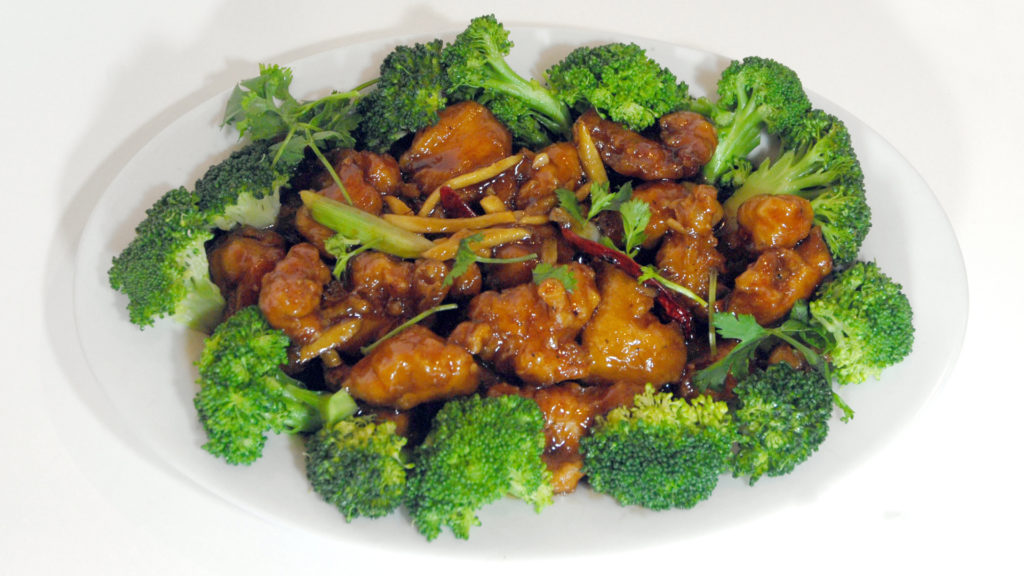 breaded chicken with general tso sauce surrounded by broccoli